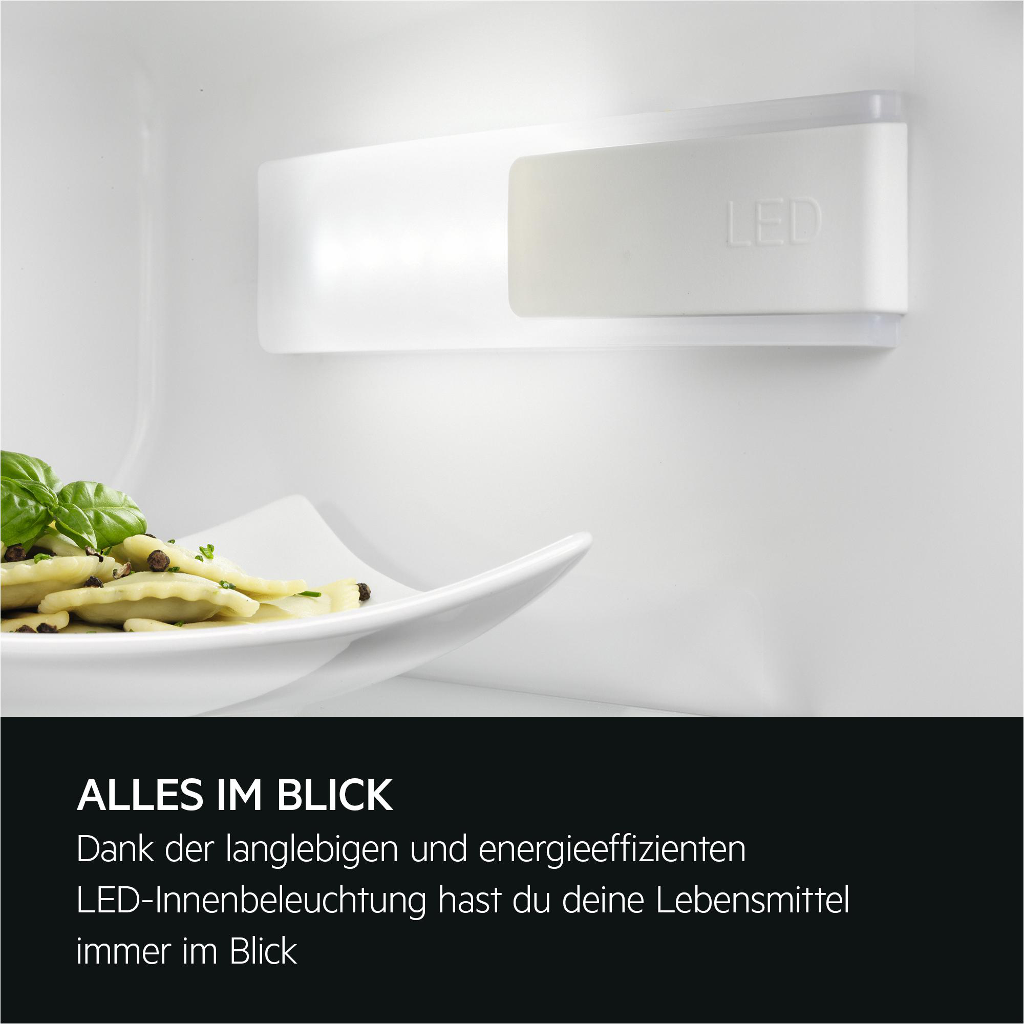 Gekochte Ravioli mit Basilikum und Pfefferkörnern auf einem Teller, LED-Licht.
