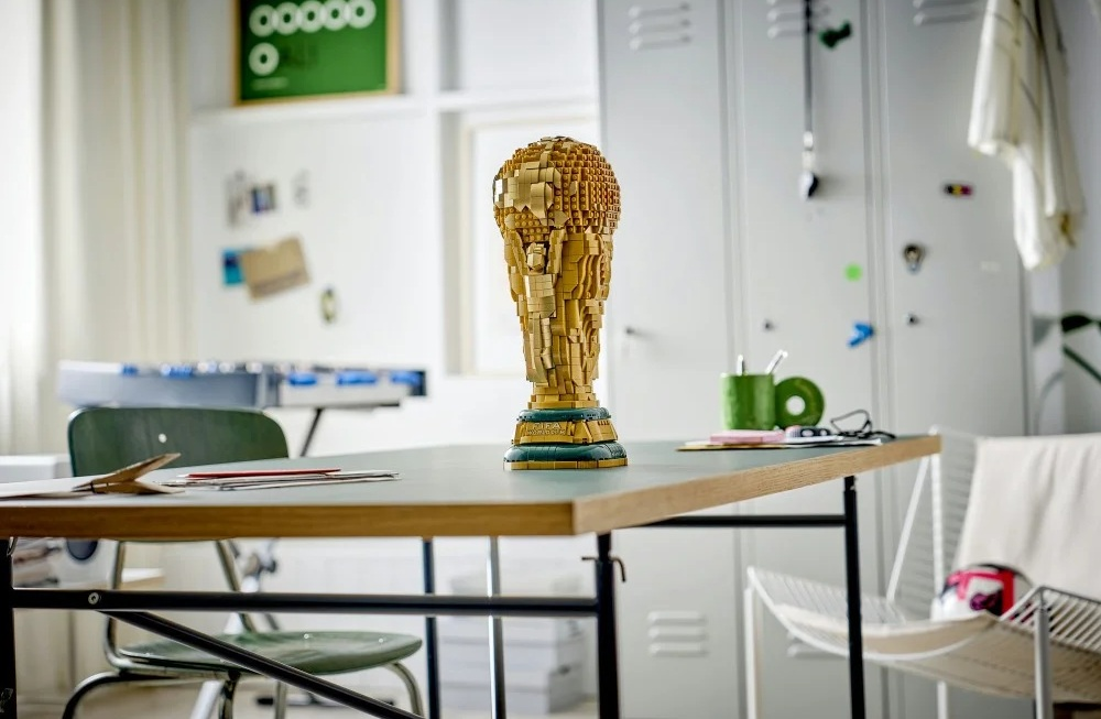 Złote trofeum Lego stoi na biurku w pokoju.