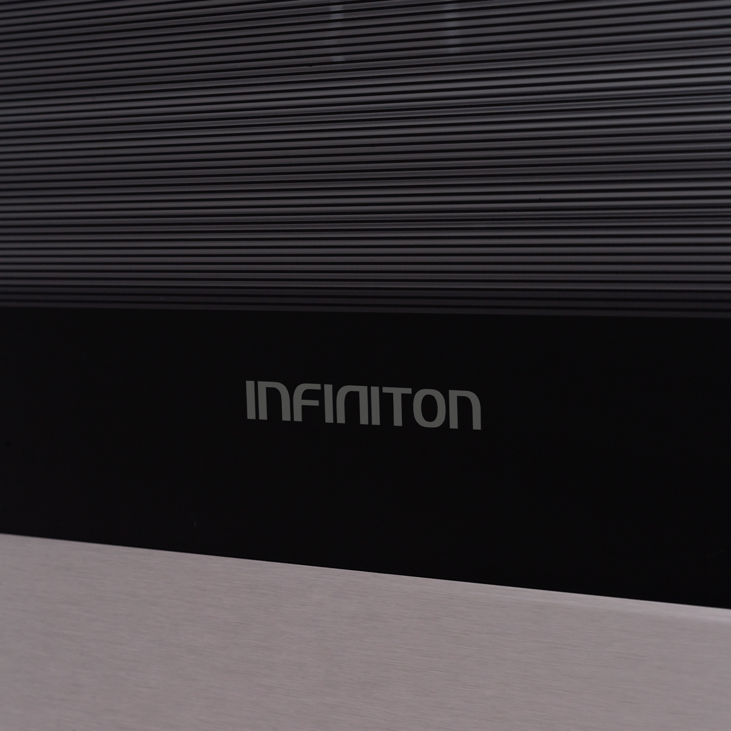 Primer plano del logo INFINITON sobre una superficie negra con líneas horizontales.