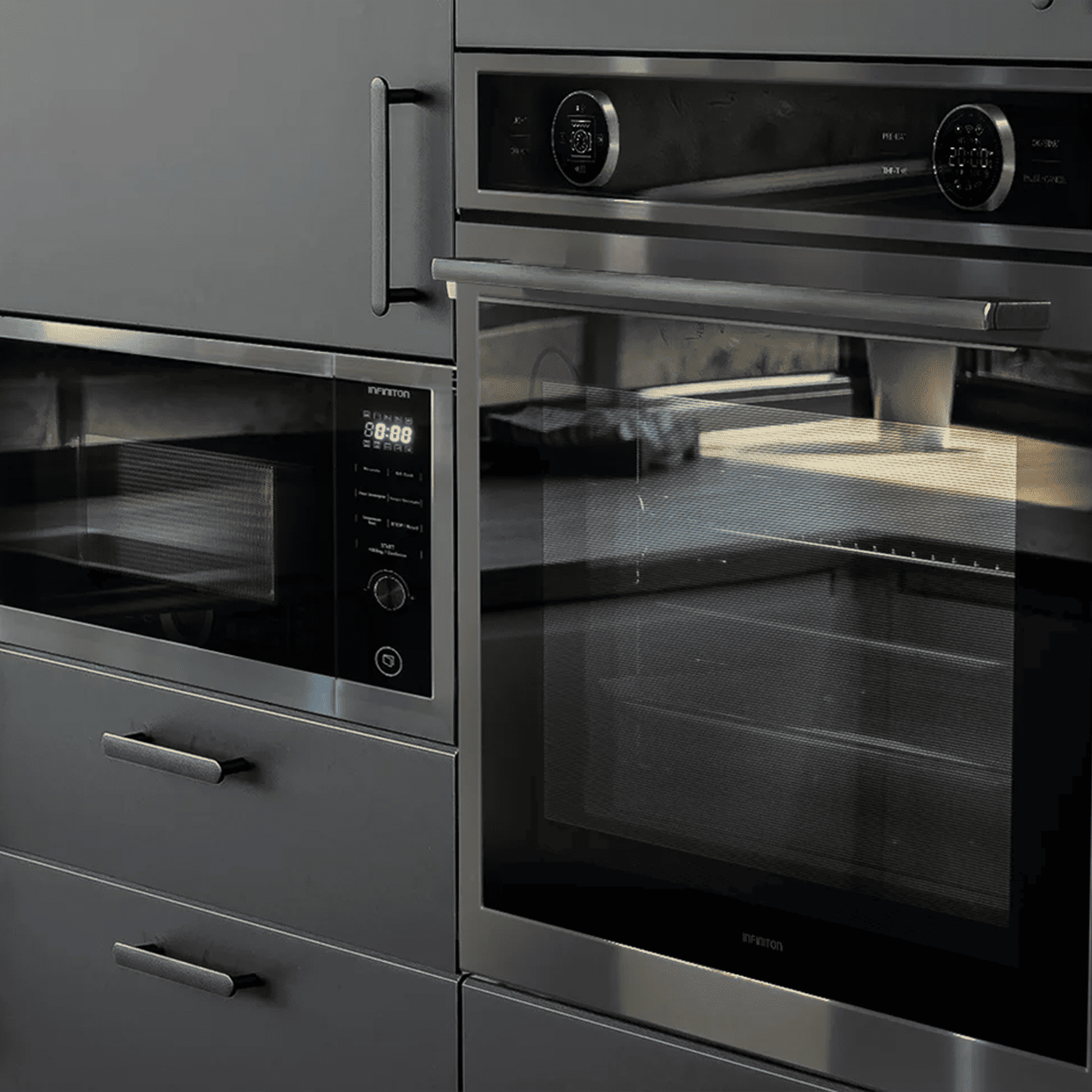 Cocina empotrada gris oscuro con microondas, horno y cajones.