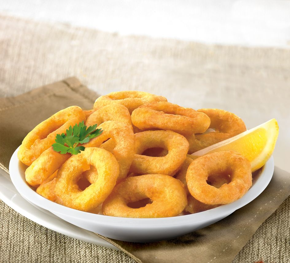 Rondelles de calamar frites avec citron et persil servies dans un bol.