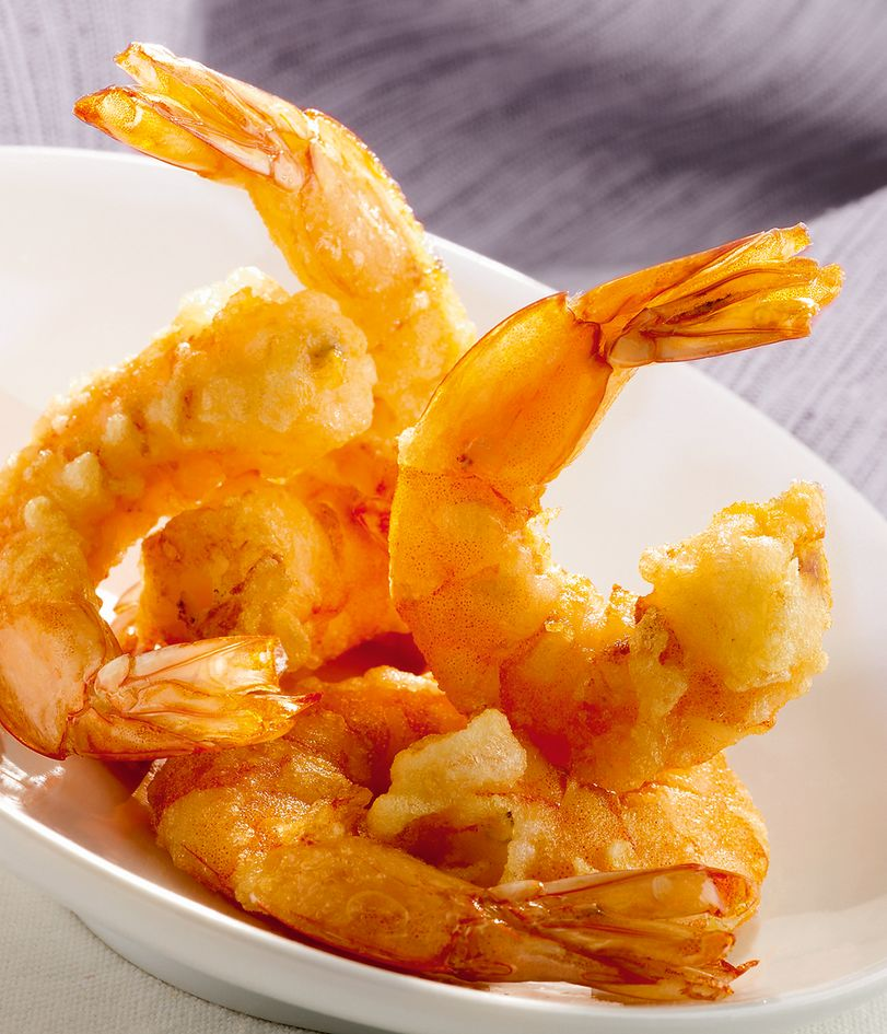 Crevettes frites dans un bol blanc, dorées et croustillantes.