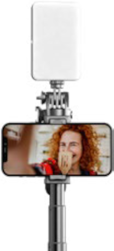 Un selfie stick con luce LED e telefono che mostra una donna che ride.