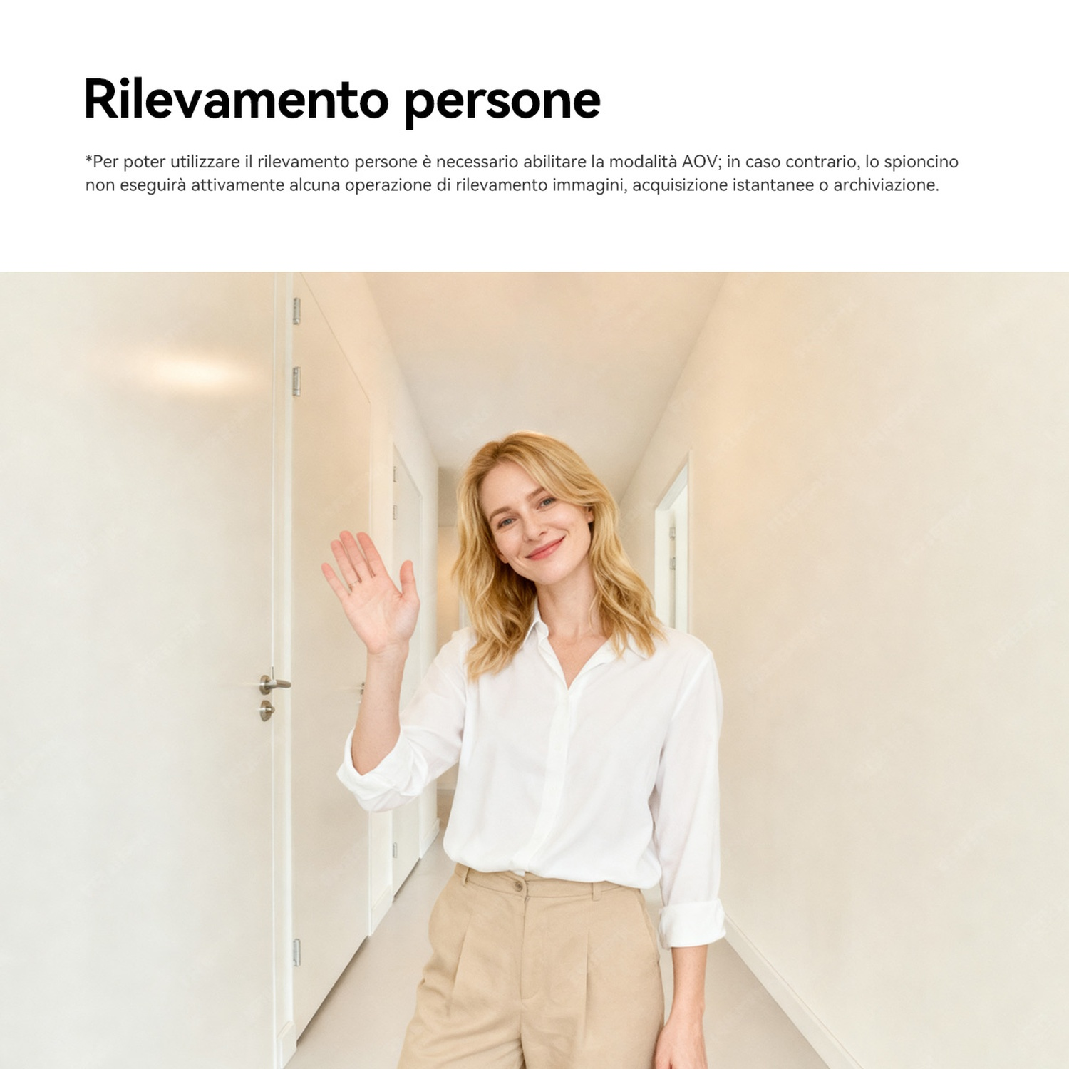 Una donna saluta in un corridoio con porte bianche.