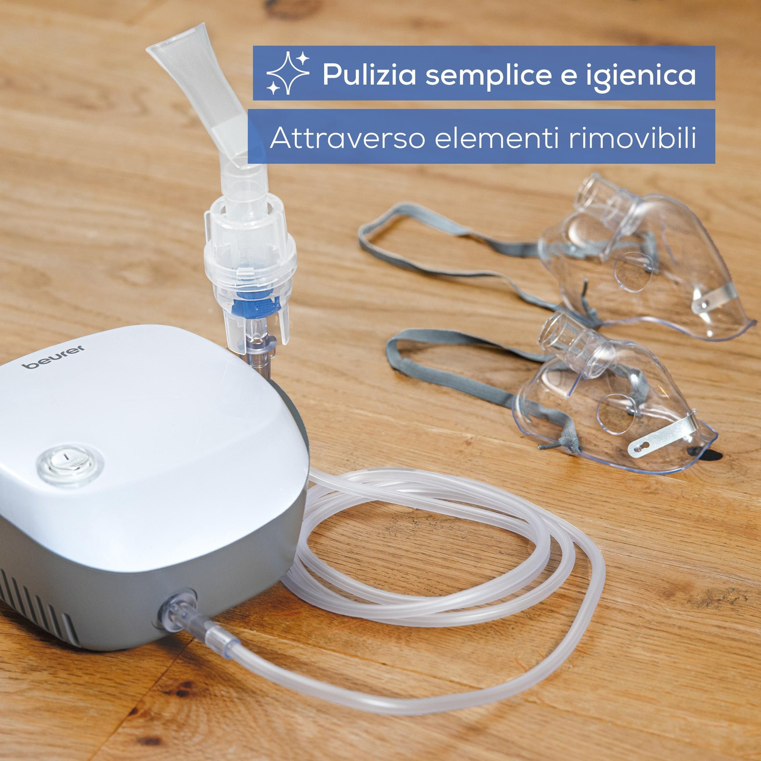 Un nebulizzatore bianco con tubi e due maschere su sfondo in legno.