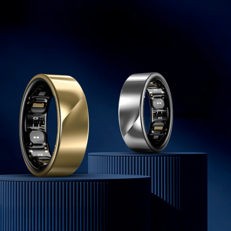 Egy arany és egy ezüst gyűrű kék dobogókon, sötétkék háttér előtt.