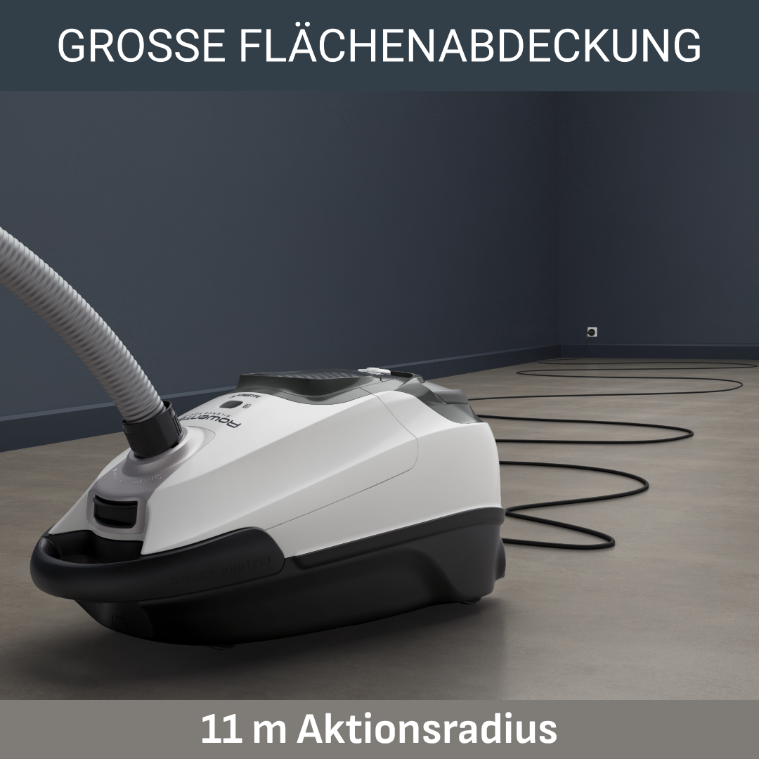 Ein weißer Staubsauger mit schwarzem Gehäuse und Schlauch auf grauem Boden.