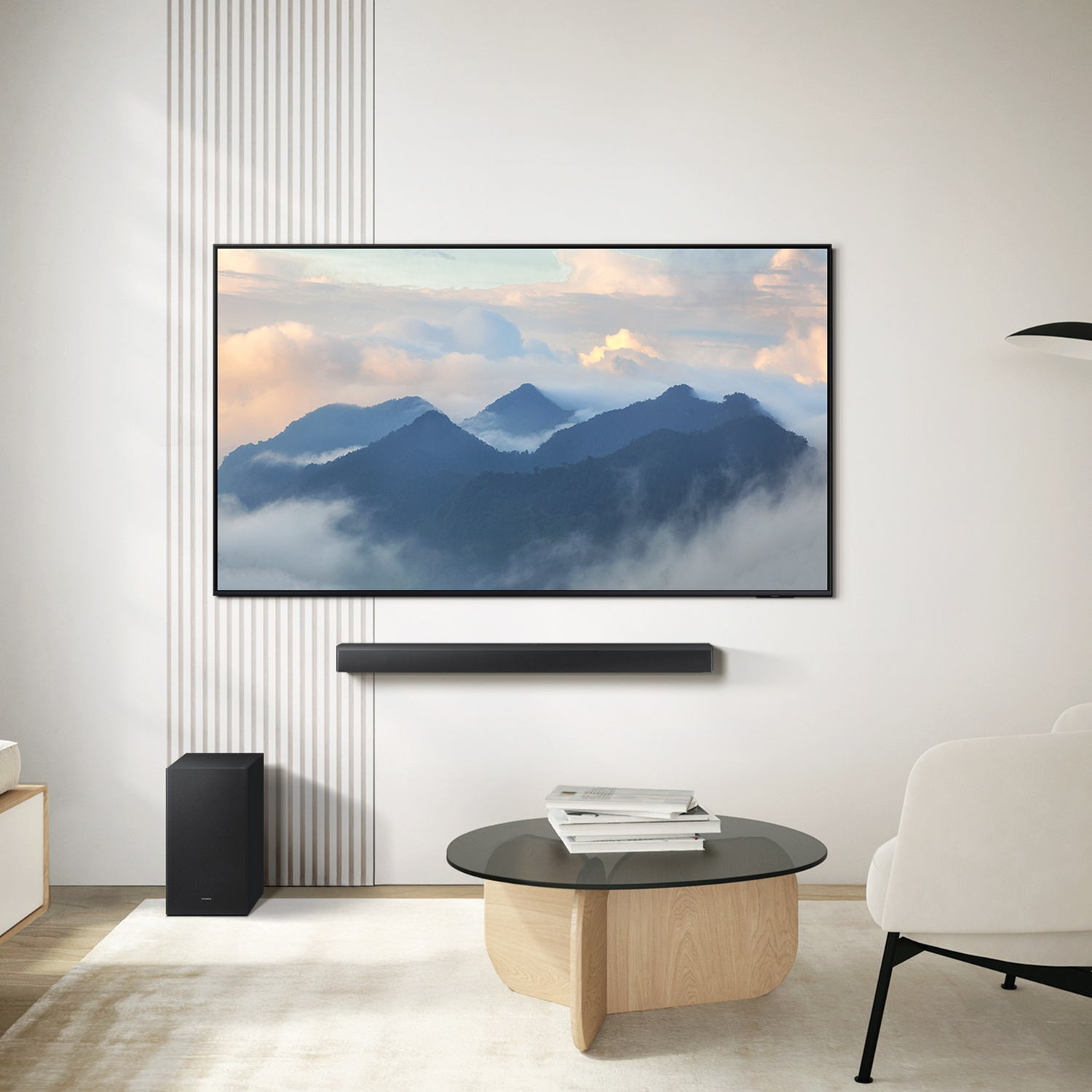 Un soggiorno con TV che mostra montagne, un subwoofer e un tavolino.