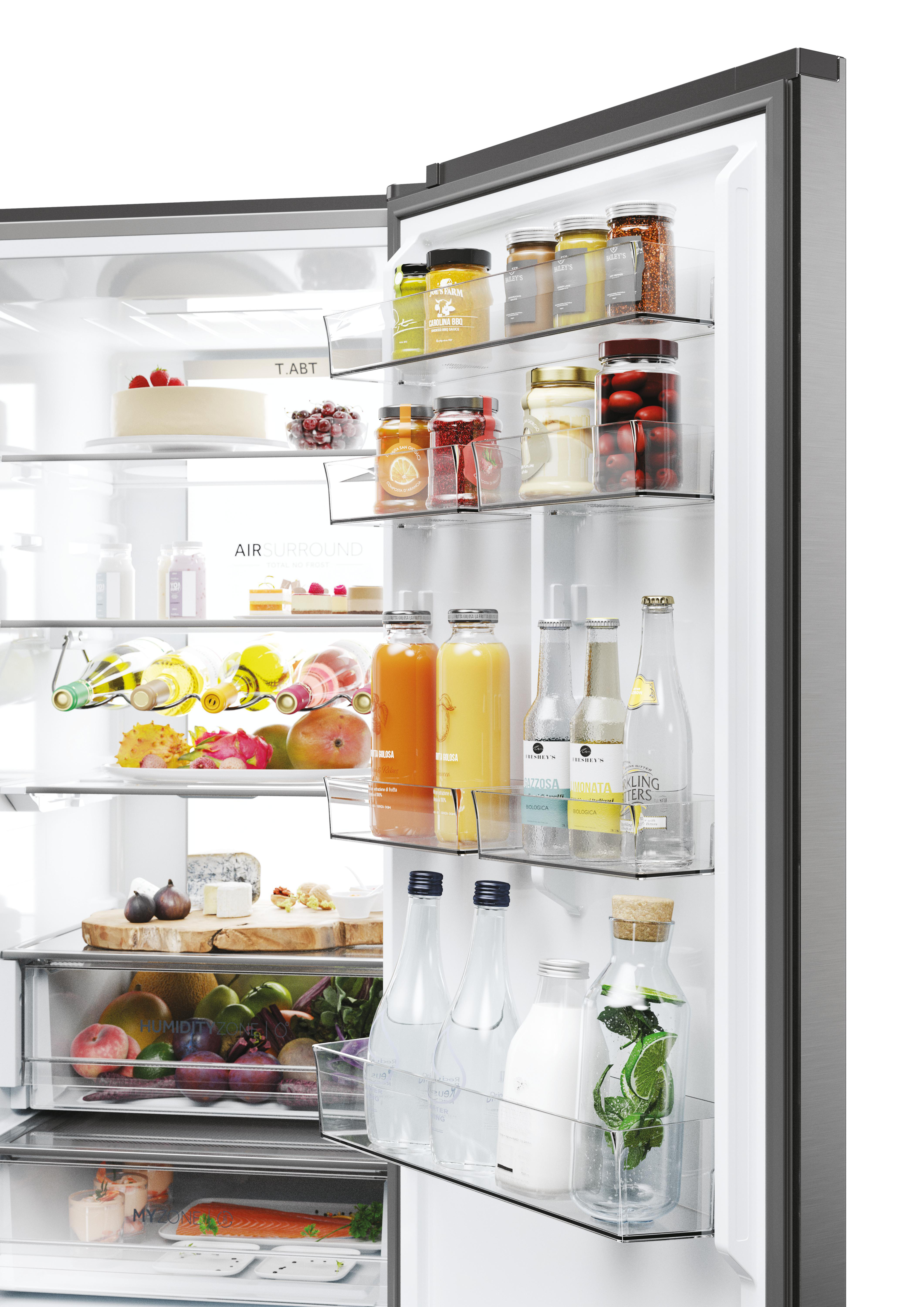 Ein offener Kühlschrank mit Lebensmitteln: Kuchen, Früchte, Getränke, Käse und Marmeladen.