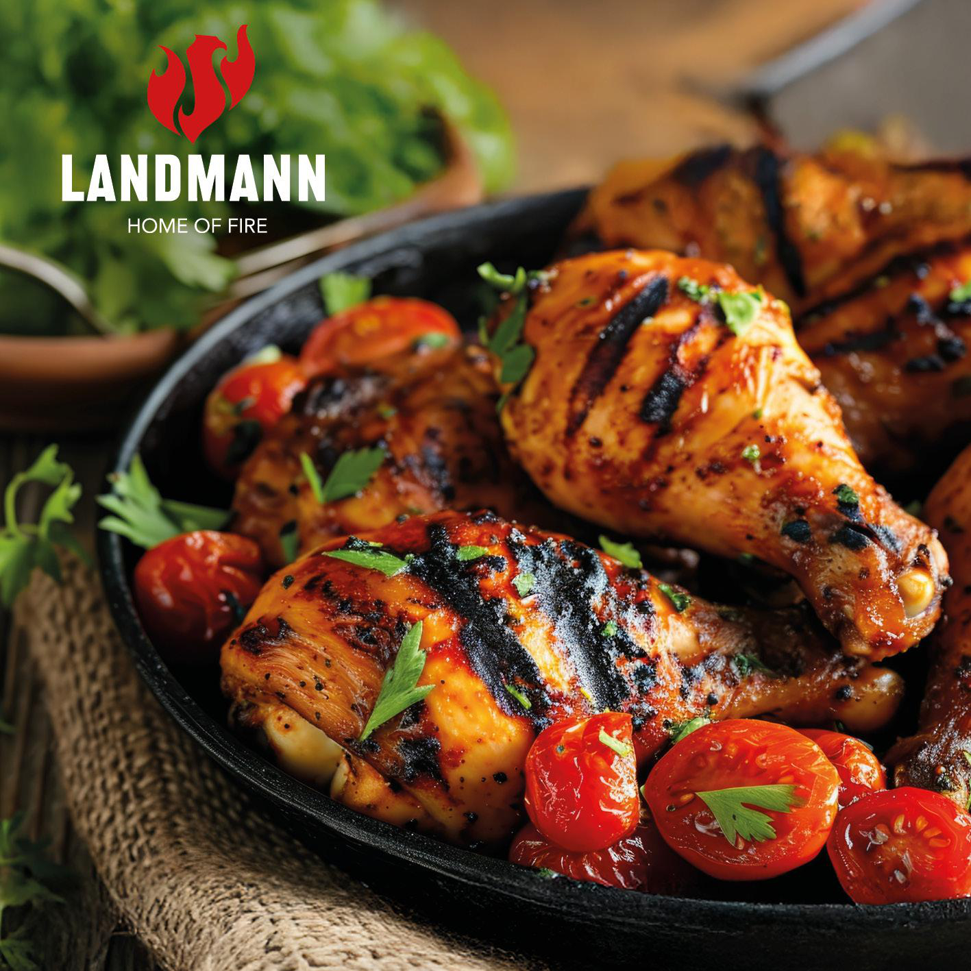 Gegrillte Hähnchenschenkel mit Kirschtomaten und Petersilie in einer Pfanne.