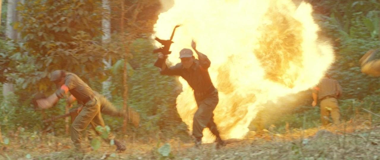 Männer in Uniform rennen vor Explosion in einem Dschungel.