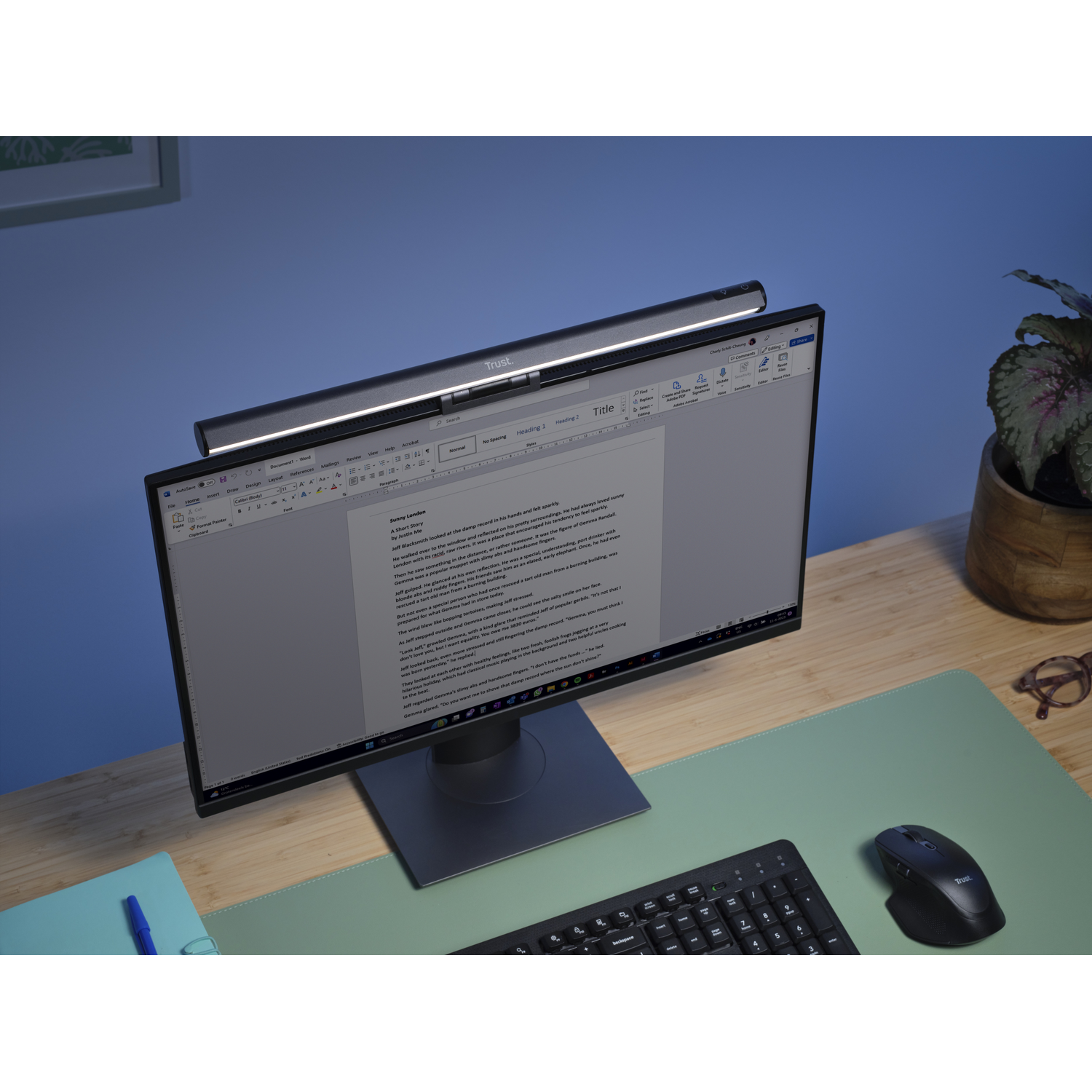 A desk setup with a monitor, keyboard, mouse, and a light.