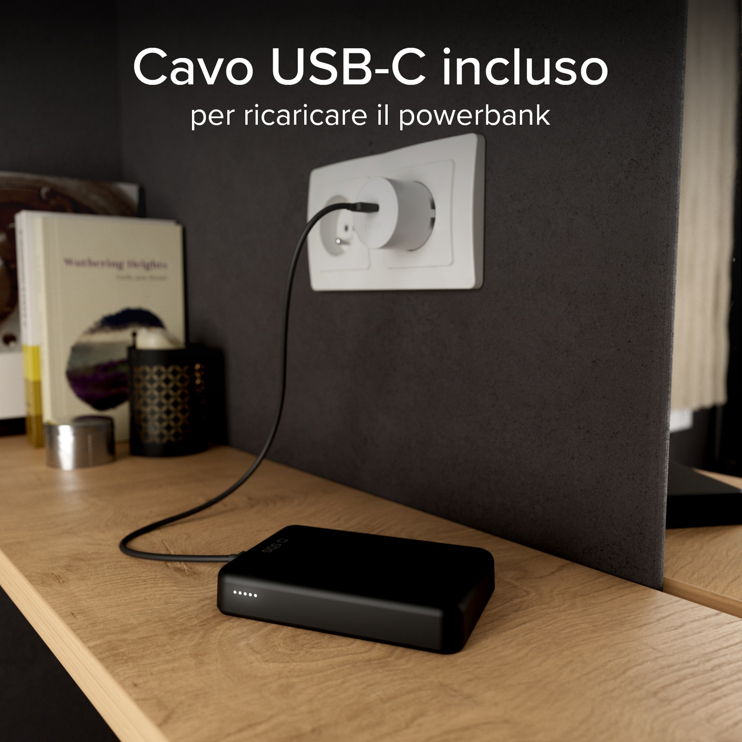 Power bank nera in carica tramite cavo USB-C collegato a presa a muro.