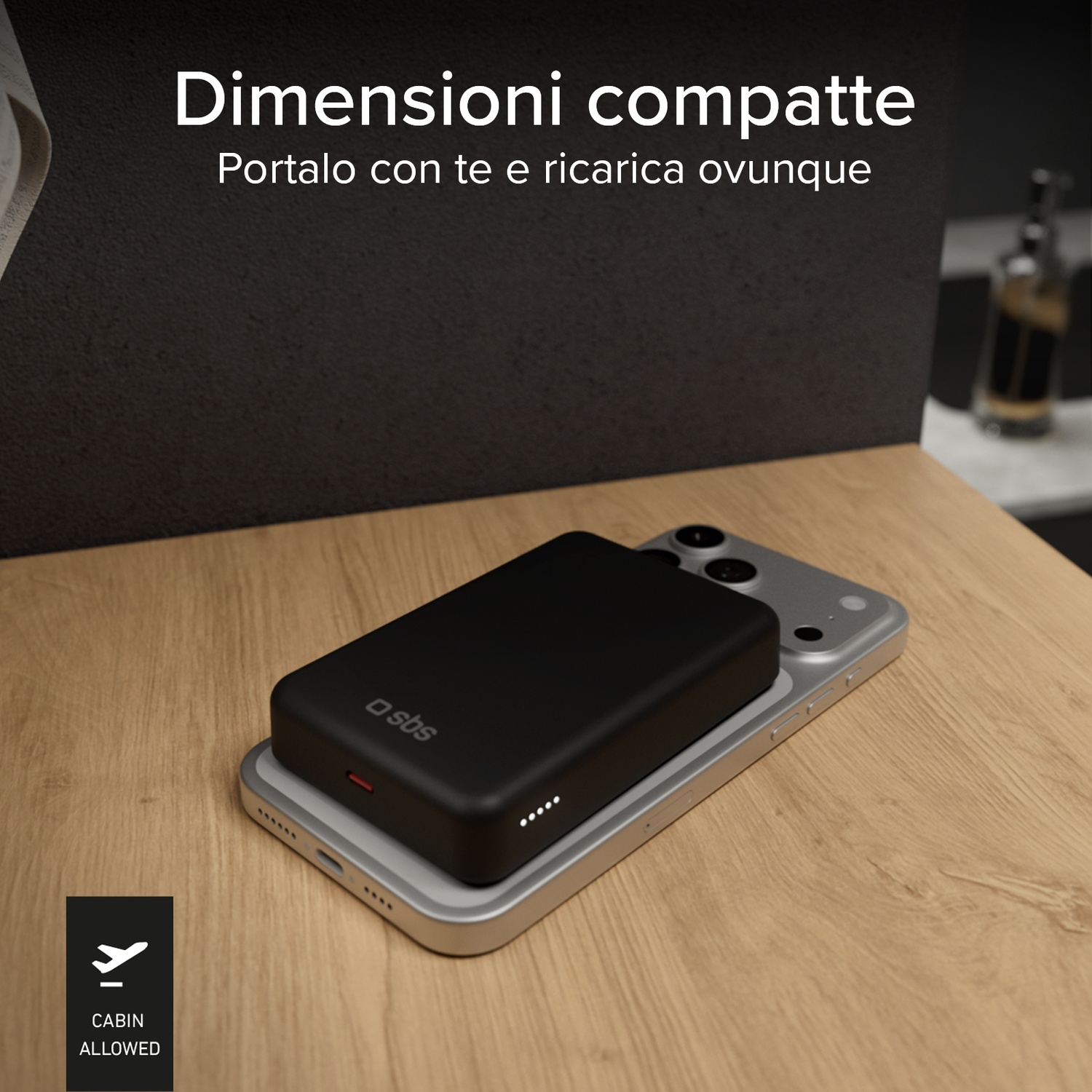 Power bank nero su telefono argento, su tavolo in legno. Icona aereo.