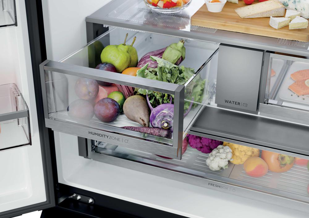 Ein offener Kühlschrank mit voller Obst- und Gemüseausstattung.