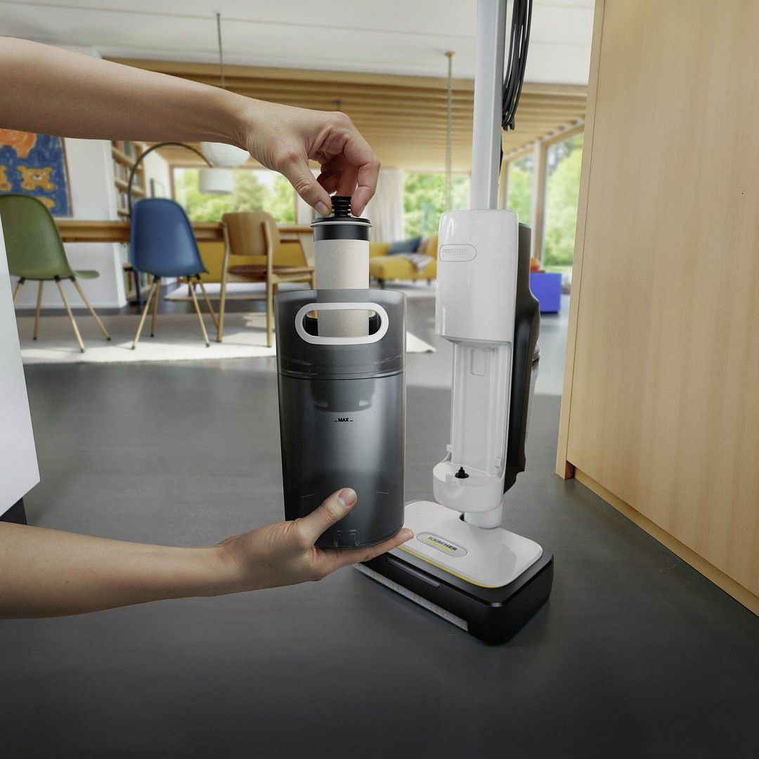 Ręka wkłada filtr do zbiornika wody czyścika podłóg.