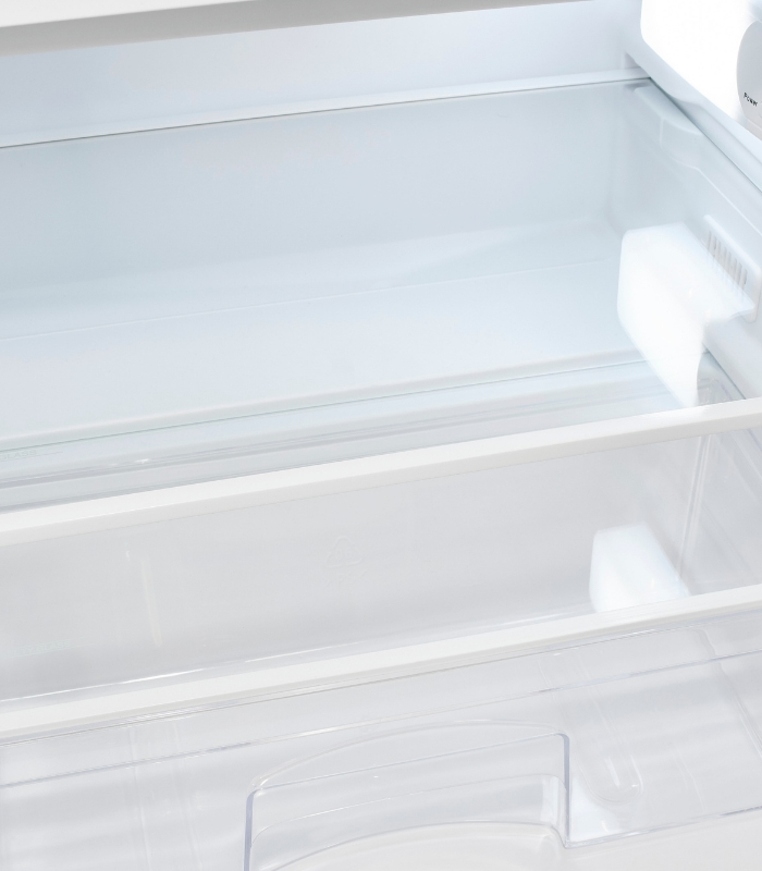 Ein leerer weißer Kühlschrank mit Glasböden und einer Schublade.