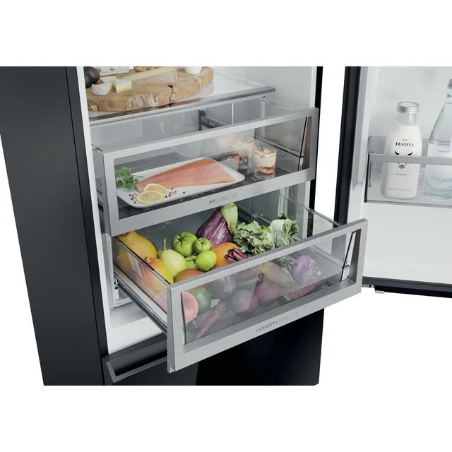 Un refrigerador abierto con cajones extraídos, lleno de frutas, verduras y pescado.