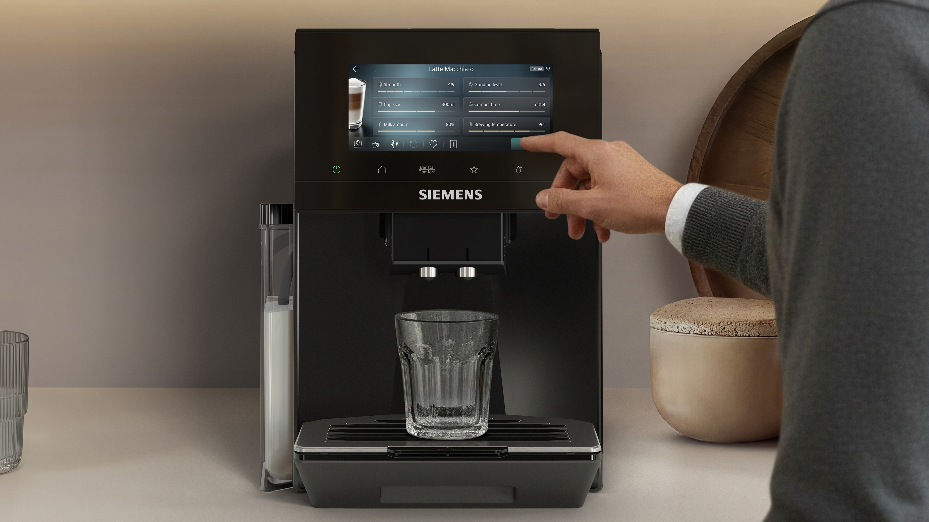 Une personne utilise une machine à café Siemens noire préparant un Latte Macchiato.