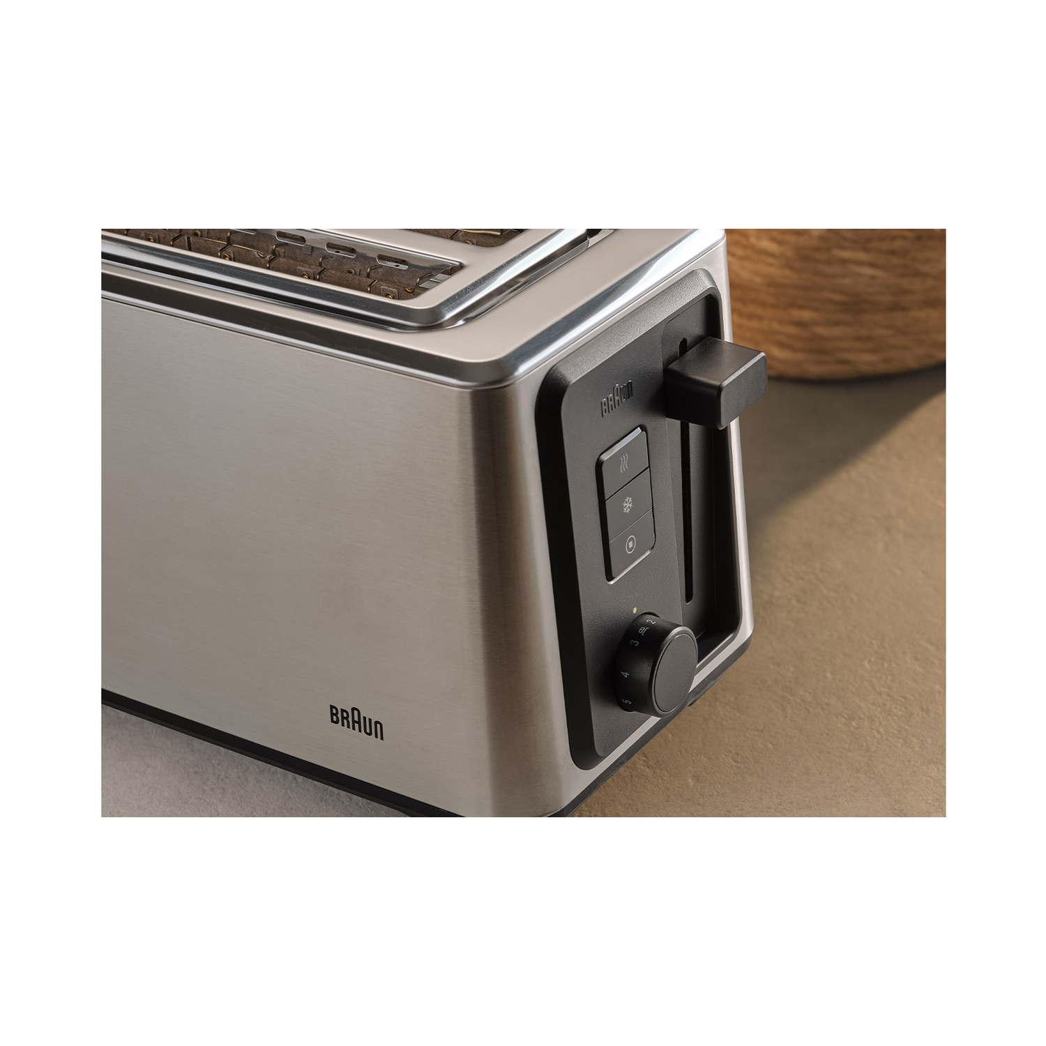 A silver toaster with black controls and a Braun logo. Close-up.