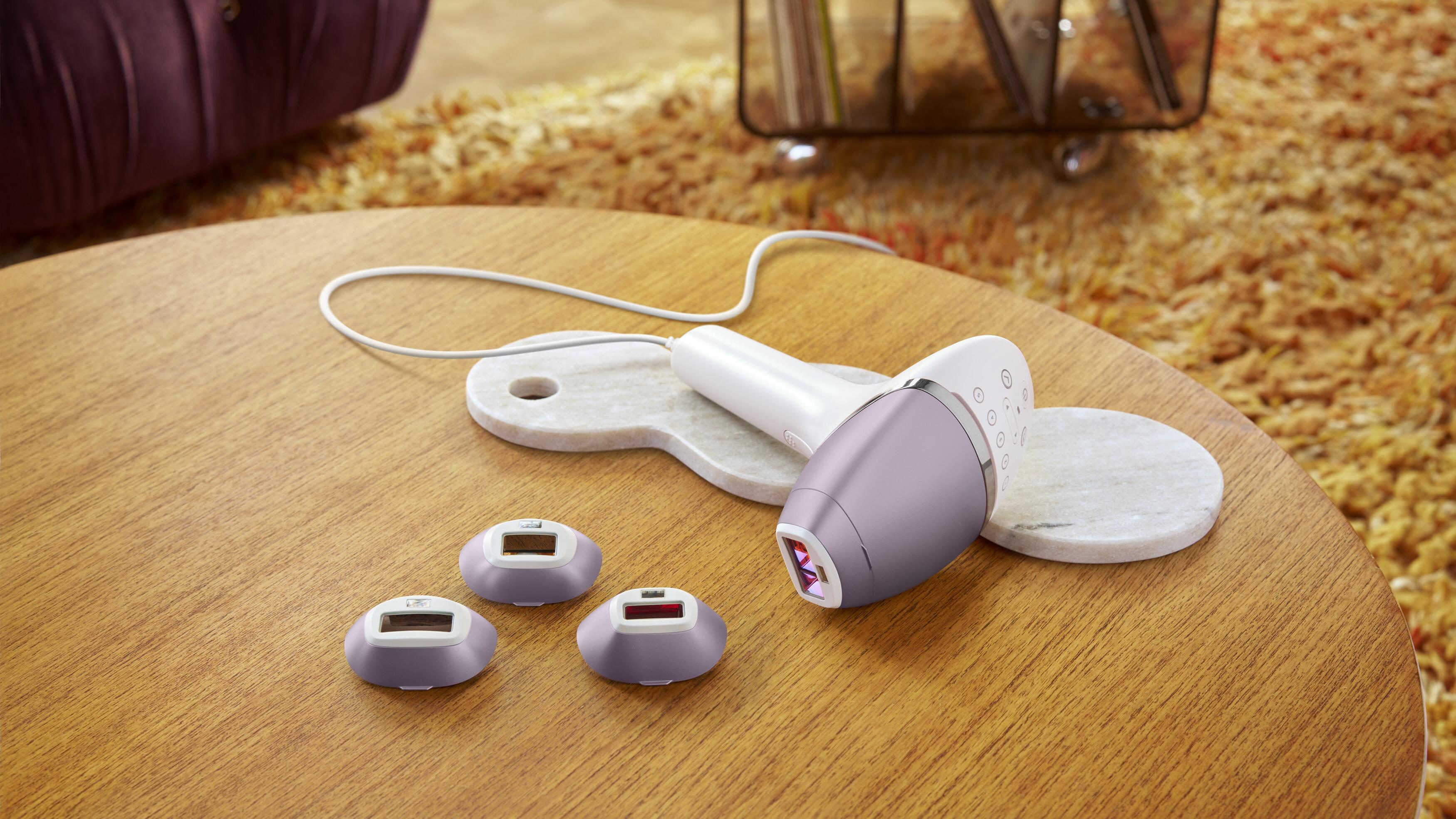 Urządzenie do depilacji IPL z nasadkami na drewnianym stole.