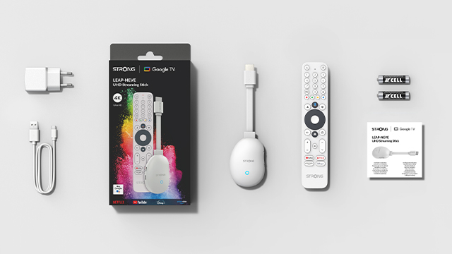 Un set de stick de streaming 4K UHD Strong con mando, adaptador, cable y pilas.