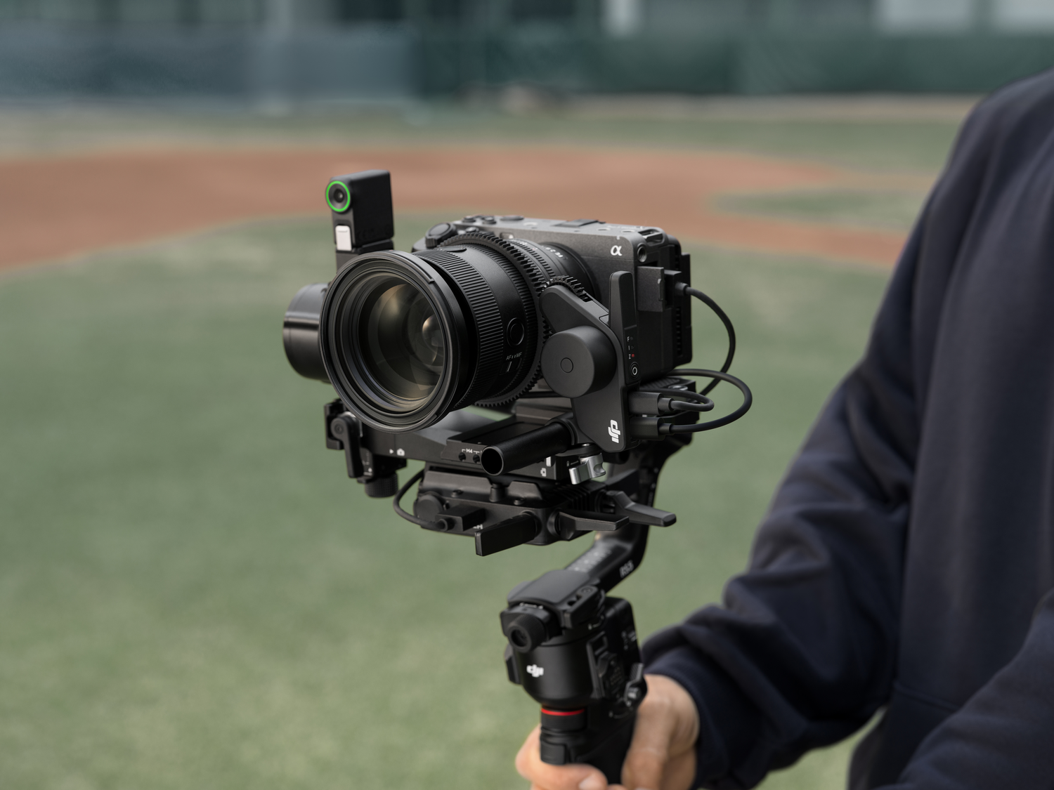 Una cámara en un cardán frente a un campo de béisbol.
