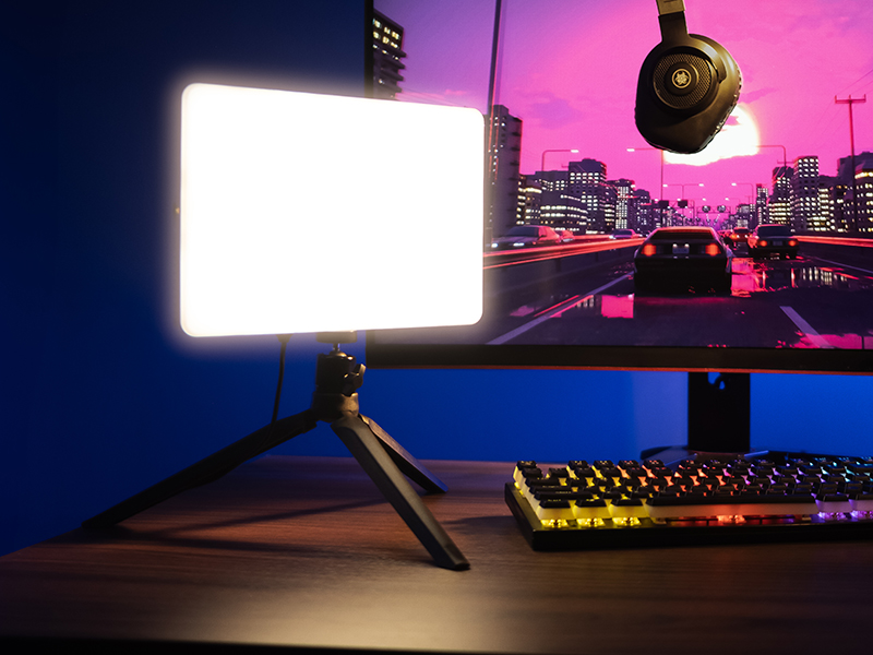 Jasne światło stoi na statywie obok klawiatury.