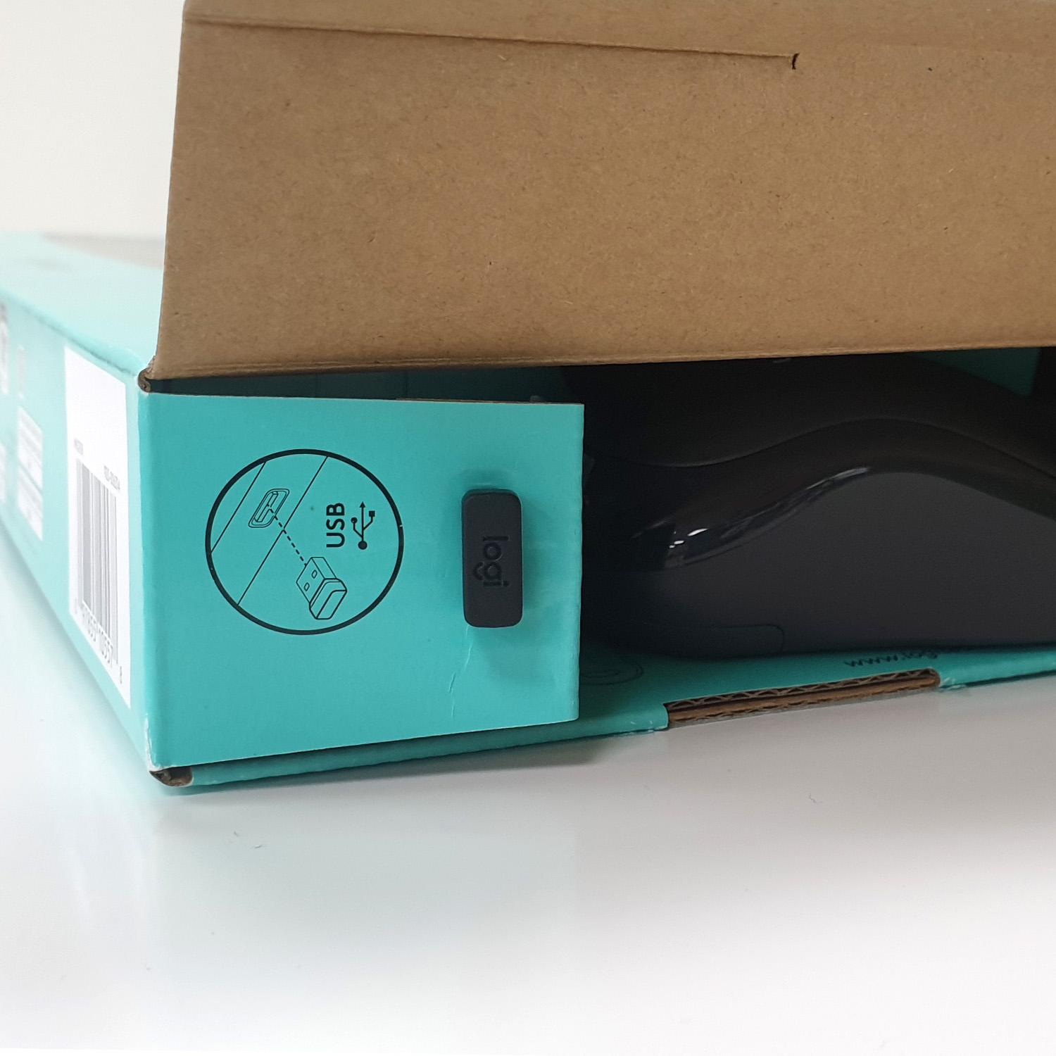 Czarna mysz z donglem USB w otwartym turkusowym pudełku.