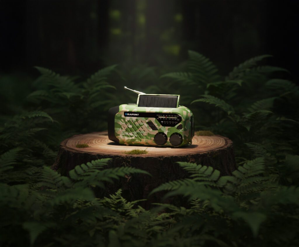 Radio w kamuflażu z panelem słonecznym stoi na pniu drzewa w lesie.