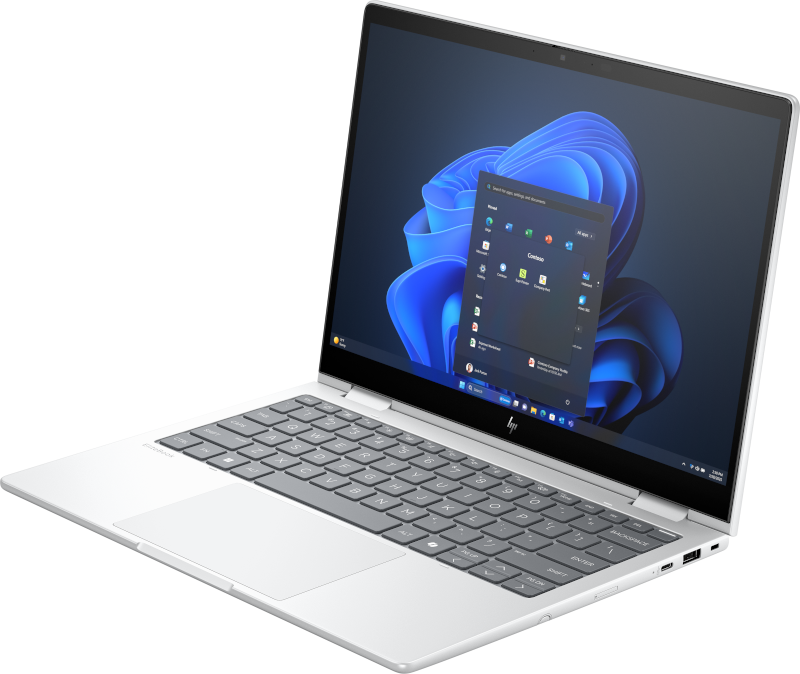 Silberner Laptop mit offenem Bildschirm, der das Windows 11-Startmenü anzeigt.