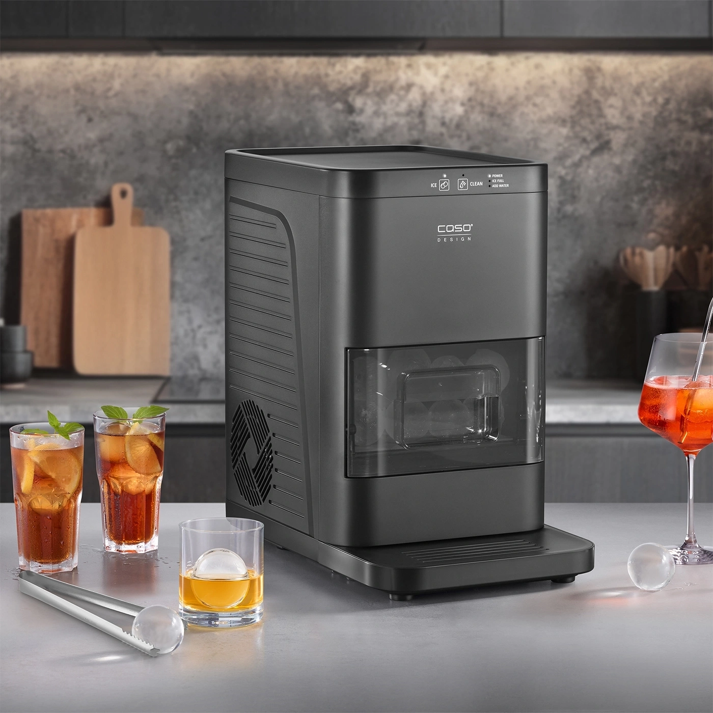 Schwarzer Eisbereiter in einer Küche mit zwei Gläsern Eistee und einem Glas Whiskey.