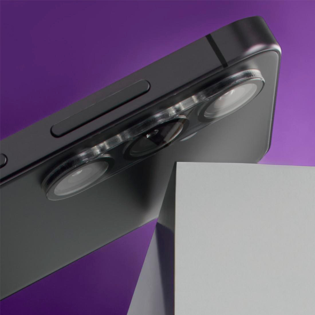 Dunkelgraues Smartphone mit drei Kameras auf violettem Hintergrund über weißem Block.