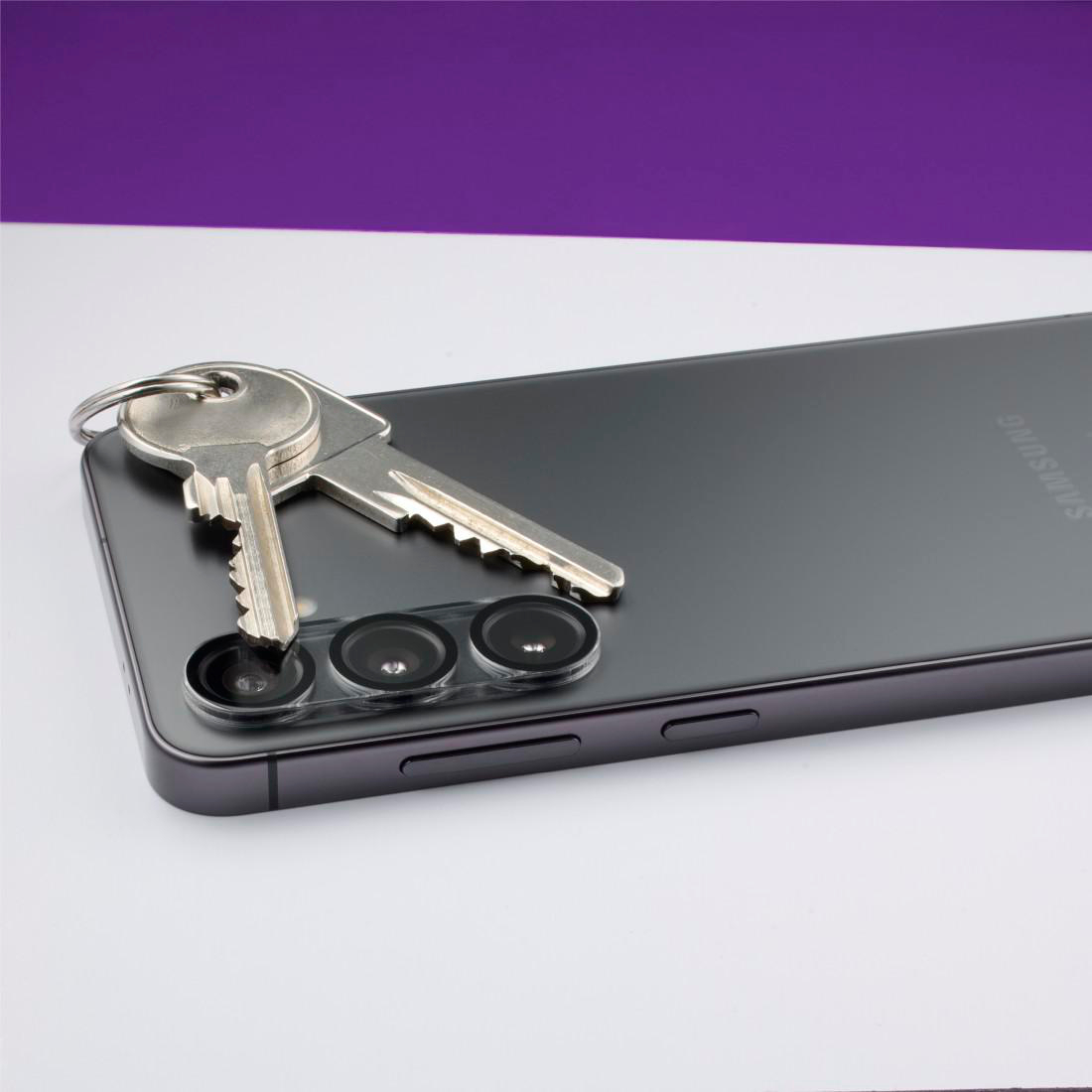 Zwei Schlüssel liegen auf einem dunklen Samsung-Smartphone mit drei Kameralinsen.