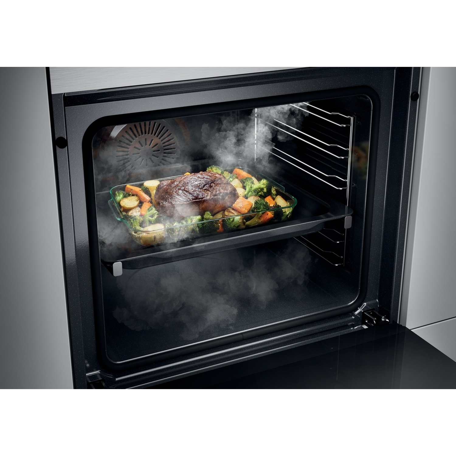 Un arrosto con verdure cuoce in un forno, vapore sale.