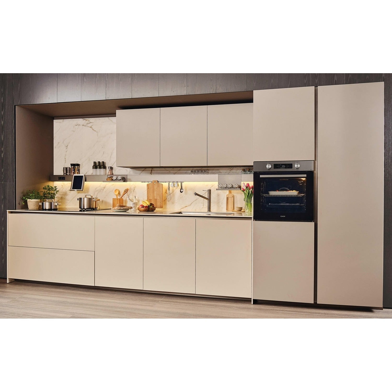 Una moderna cucina color crema con accenti in marmo, forno e pavimento in legno.