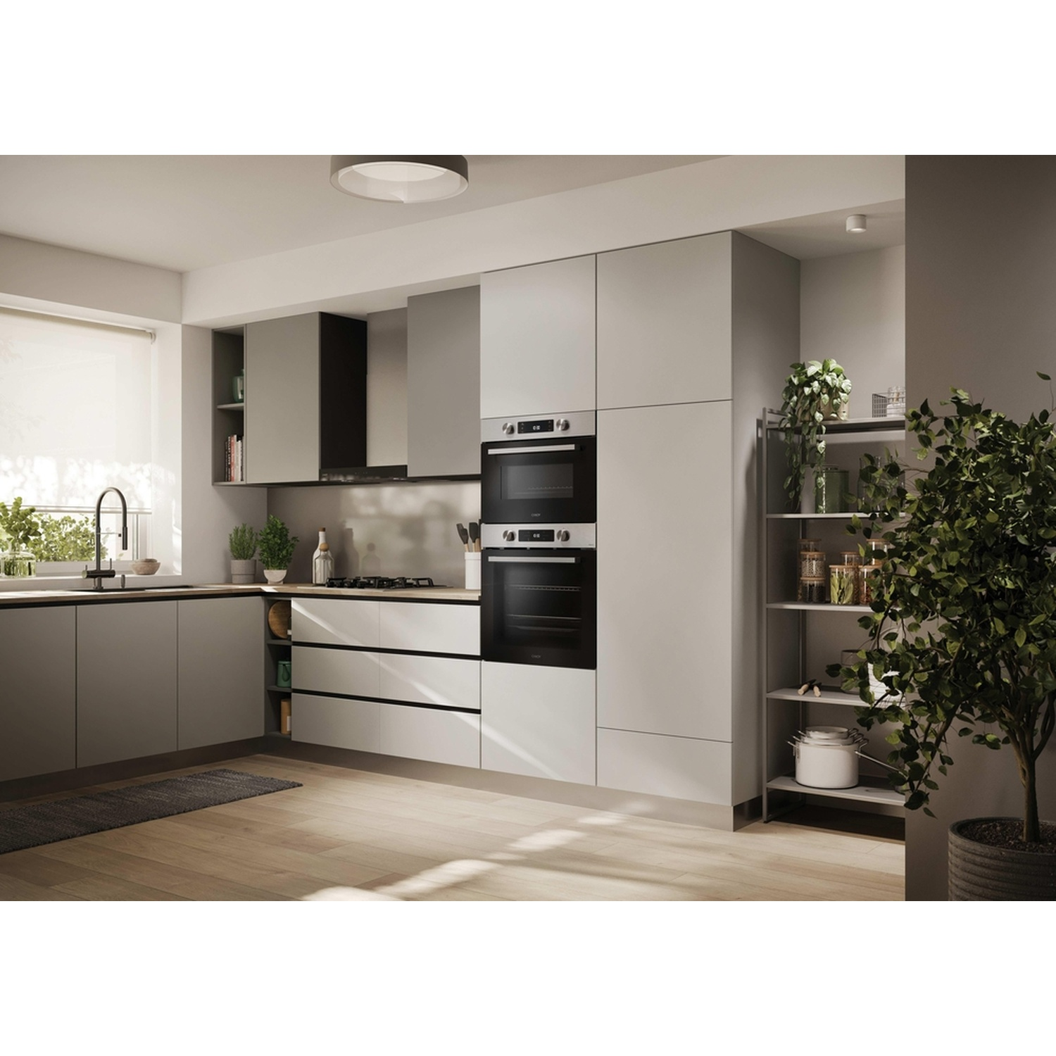 Cucina moderna grigia con doppio forno, piano cottura a gas, lavello e piante.
