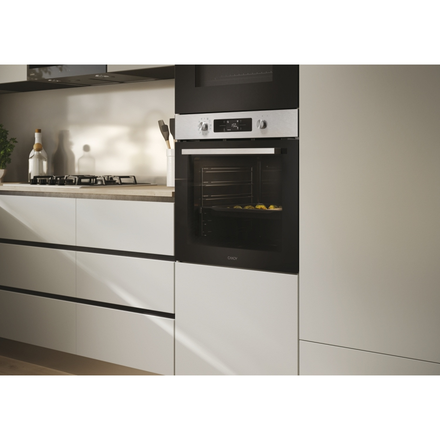 Forno da cucina moderno con frontale argento che cuoce biscotti. Accanto, piano cottura a gas.