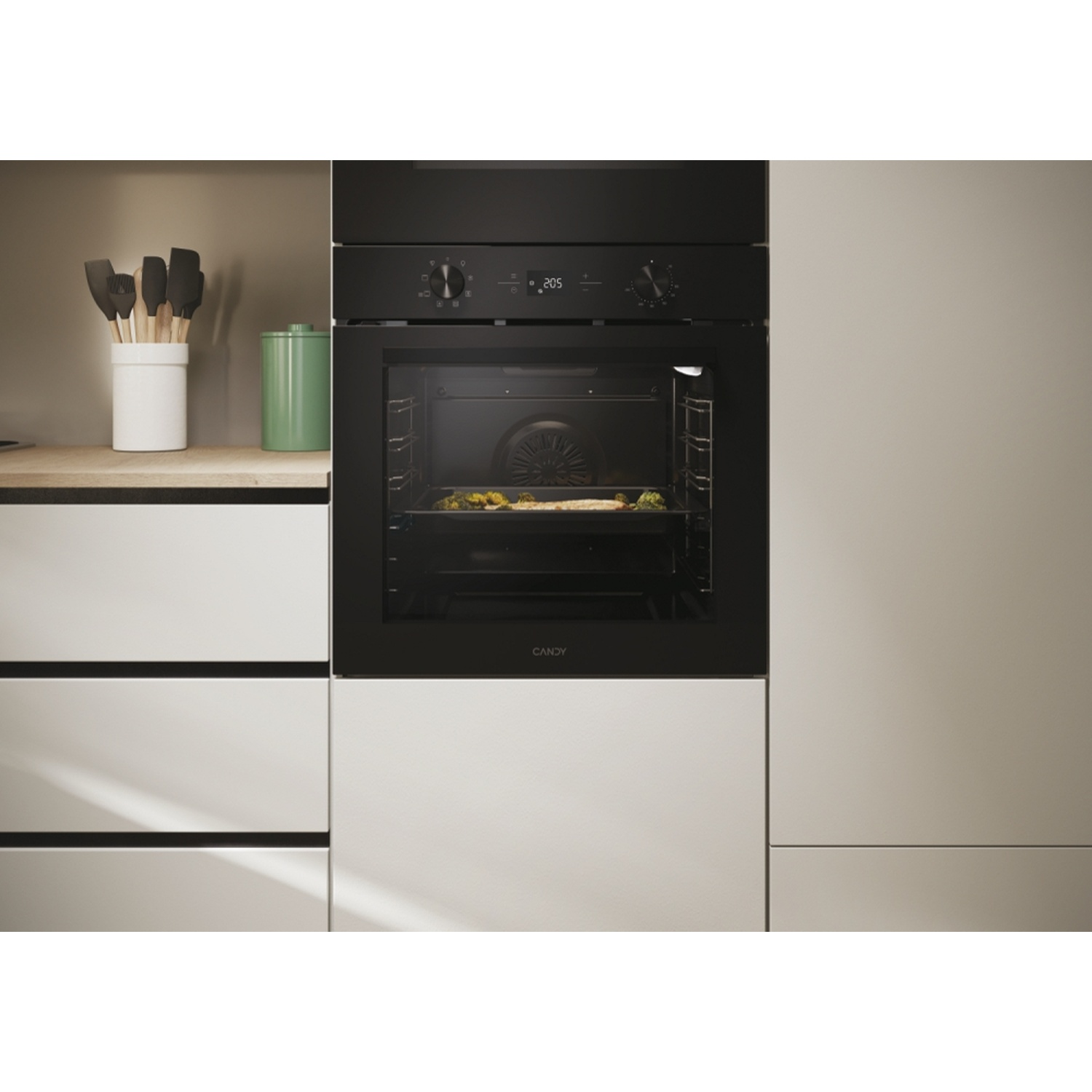 Un moderno forno nero con un piatto all'interno.