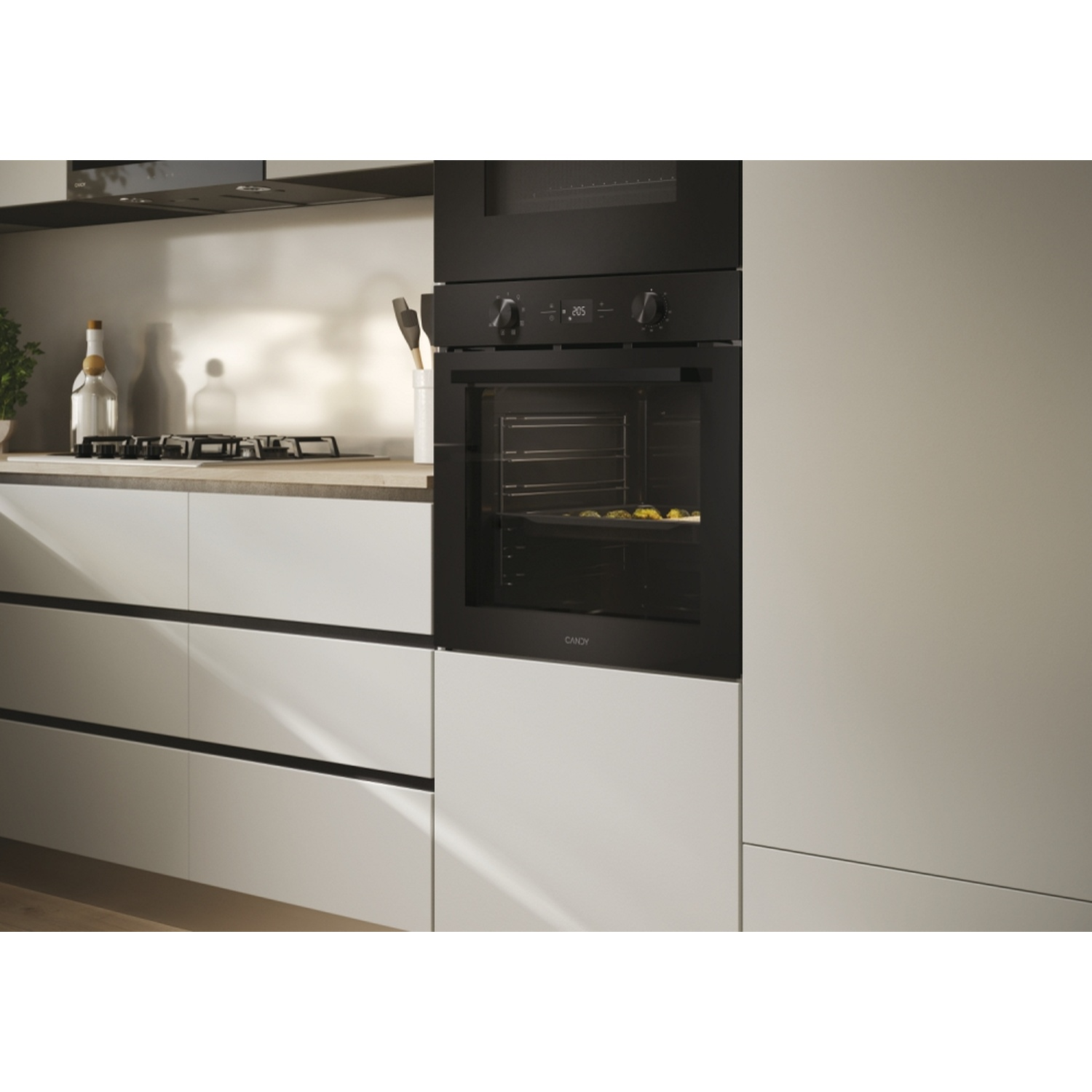 Un moderno forno nero con teglia e piano cottura nelle vicinanze.