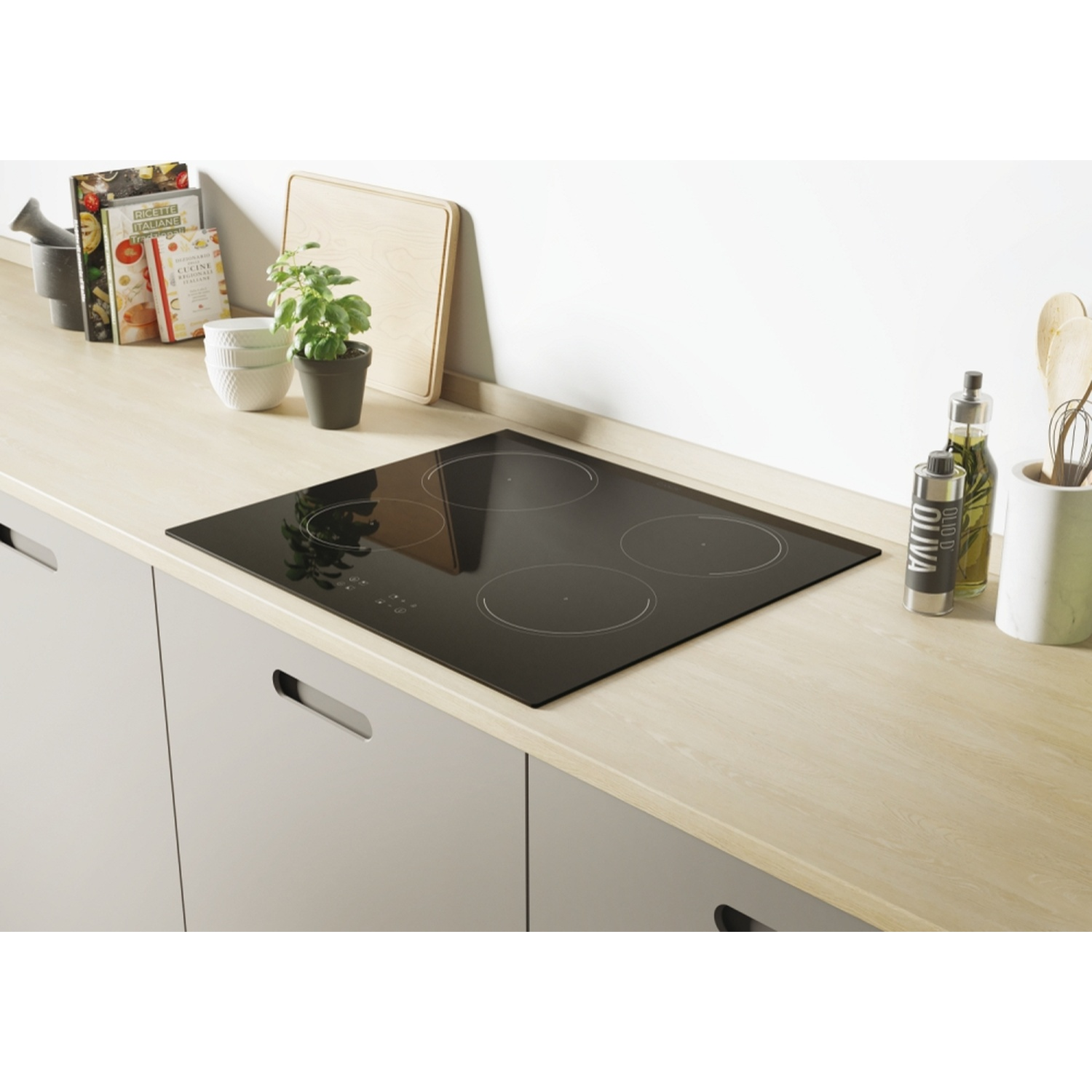 Un moderno piano cottura a induzione nero su un piano di lavoro in legno chiaro con utensili.