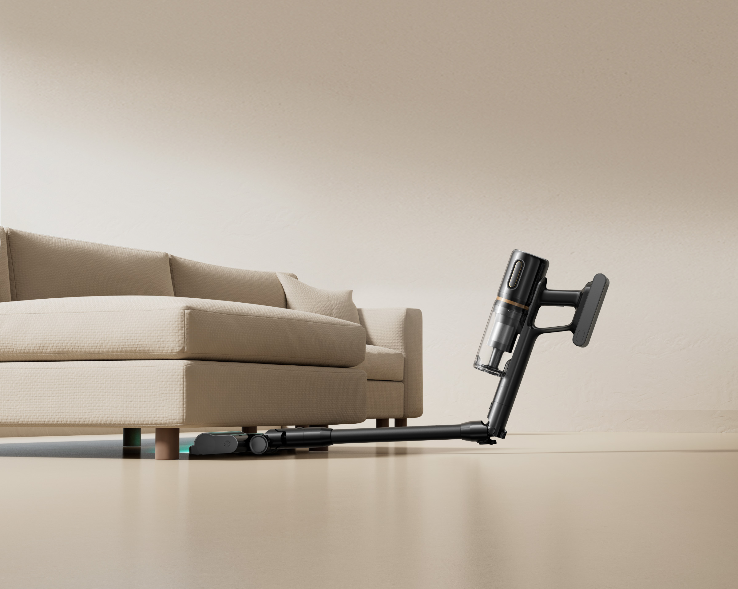 Czarny odkurzacz bezprzewodowy czyści pod beżową sofą na jasnej podłodze.