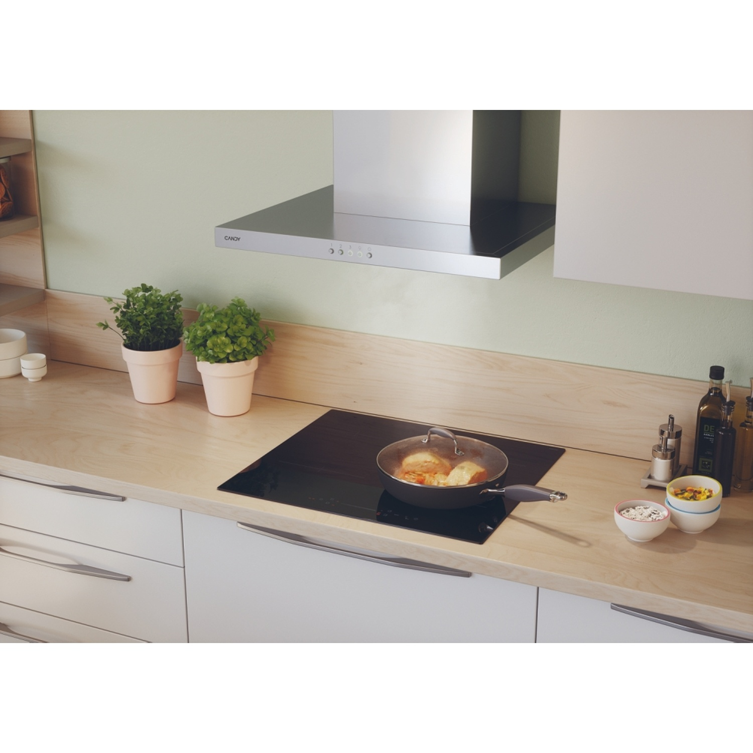 Una padella con cibo su un piano cottura a induzione in una cucina.