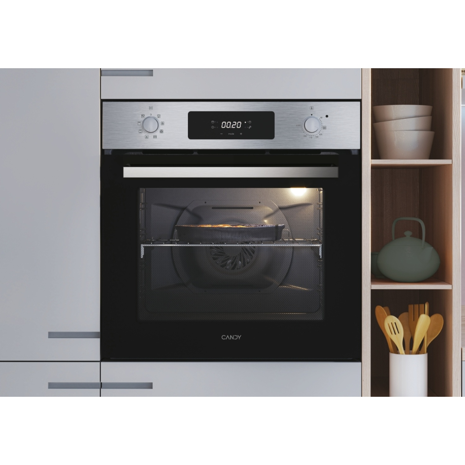 Forno da incasso in acciaio inox con display digitale e interno illuminato. Accanto, mensola con ciotole e utensili.