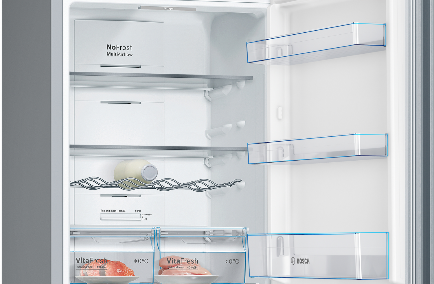 Un refrigerador abierto con estantes y cajones, parcialmente abastecido con alimentos.