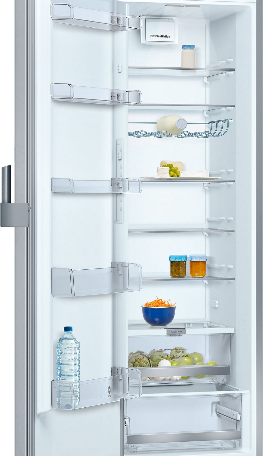 Un refrigerador abierto con alimentos como botellas de agua, queso, uvas y verduras.