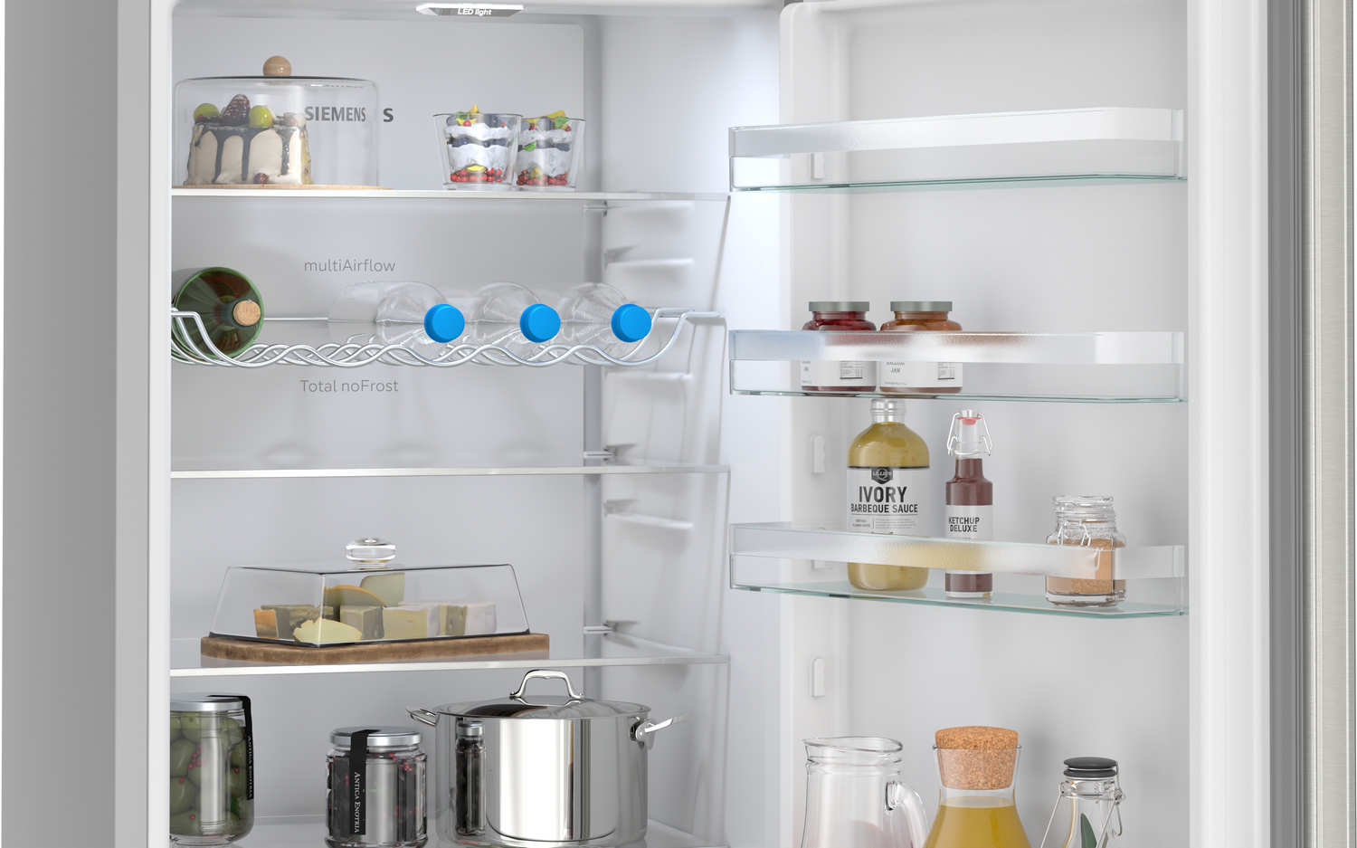 Un refrigerador abierto lleno de alimentos como pastel, postres, botellas y frascos.