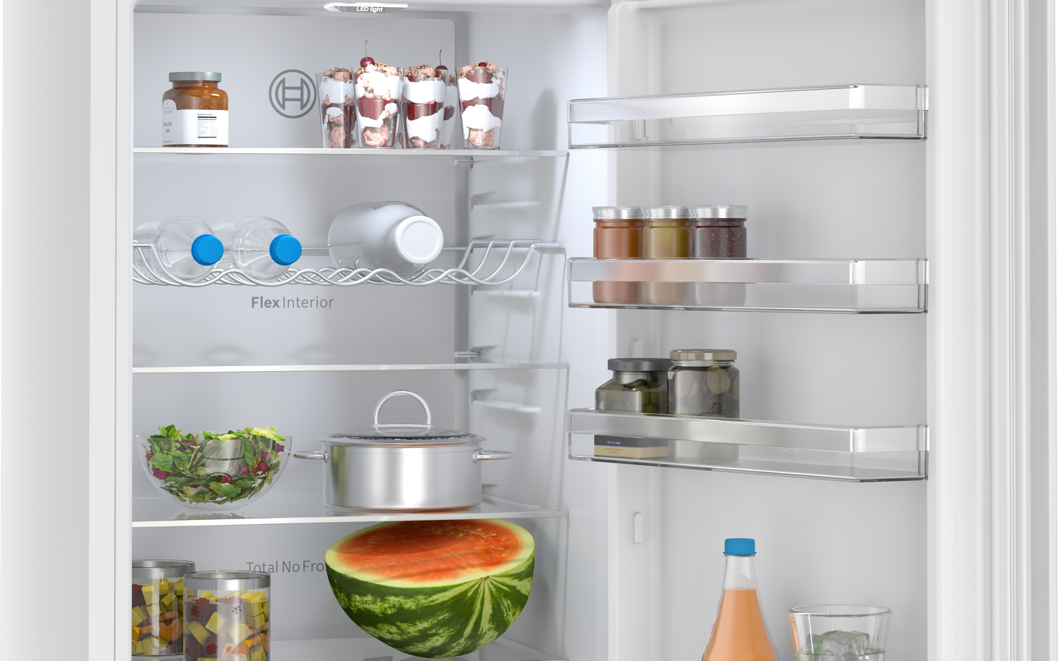 Refrigerador abierto con comida: frascos, bebidas, ensalada, olla, sandía, postres.