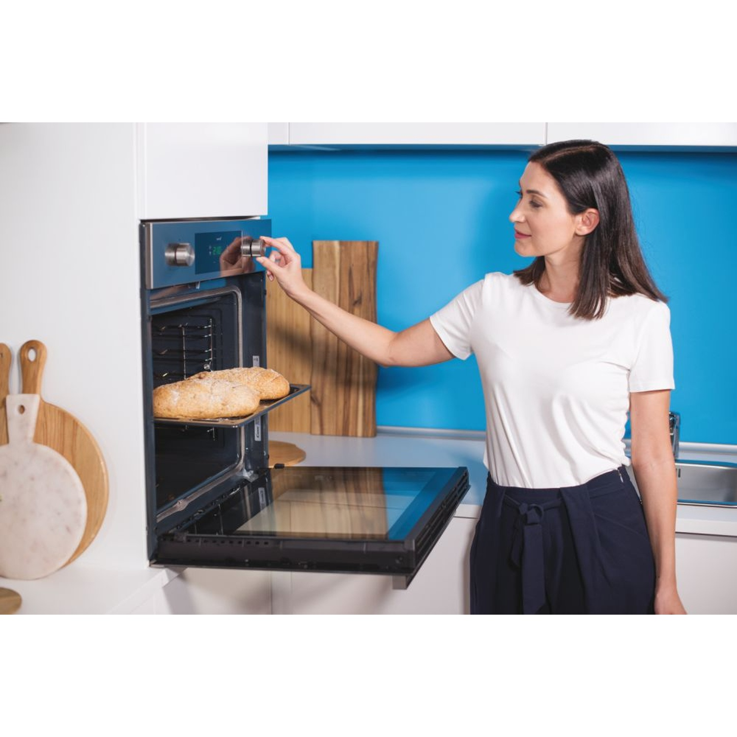 Una donna regola il forno con il pane sulla griglia.