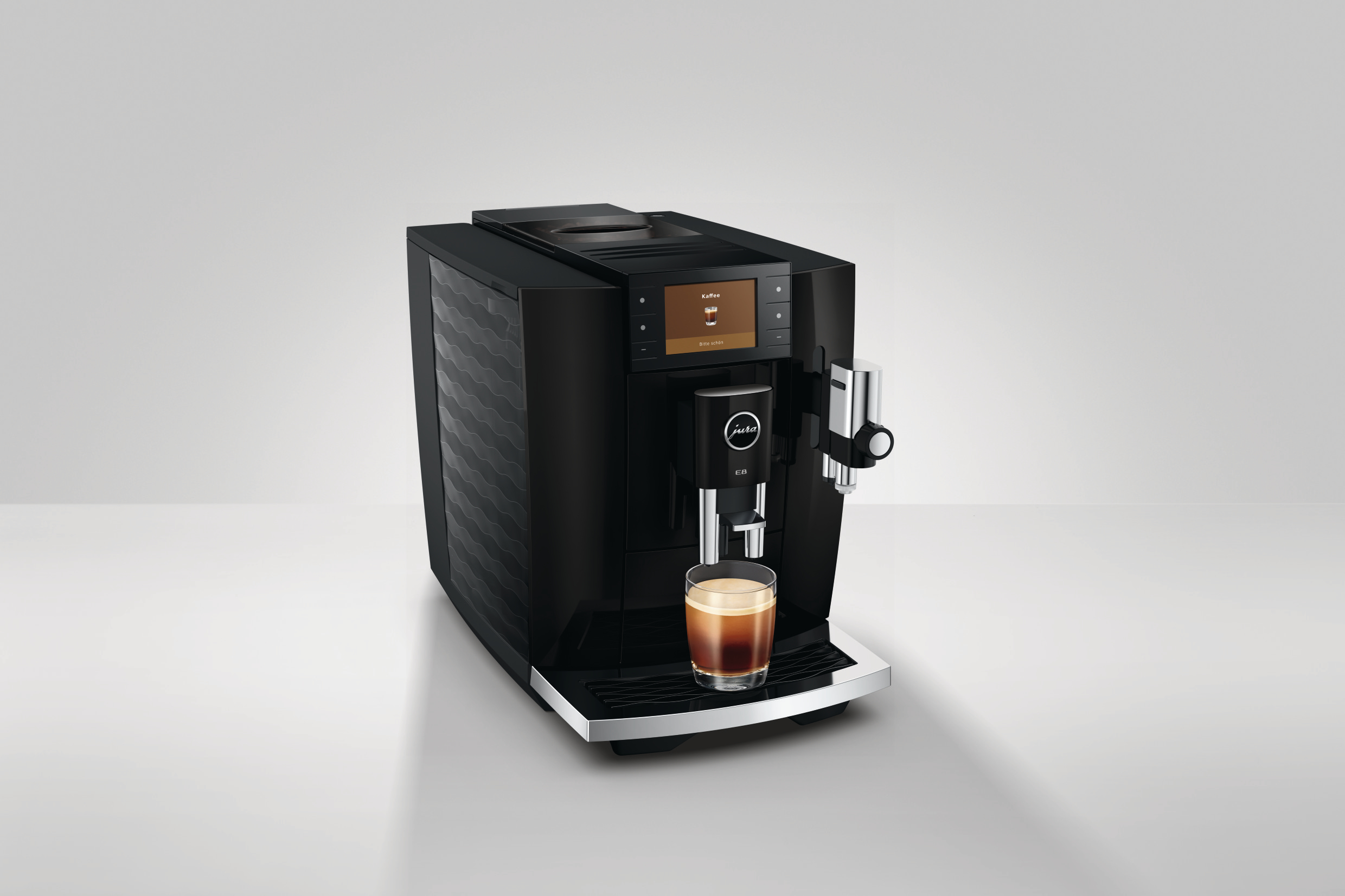 Schwarze Kaffeemaschine mit einem Glas Espresso und einem Touchscreen-Display.